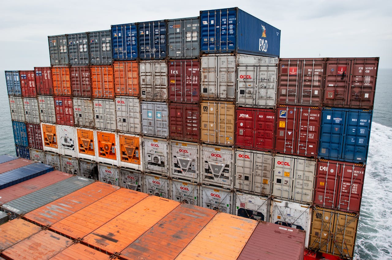 Colorful stacked shipping containers on a cargo ship traveling at sea, showcasing global trade.
